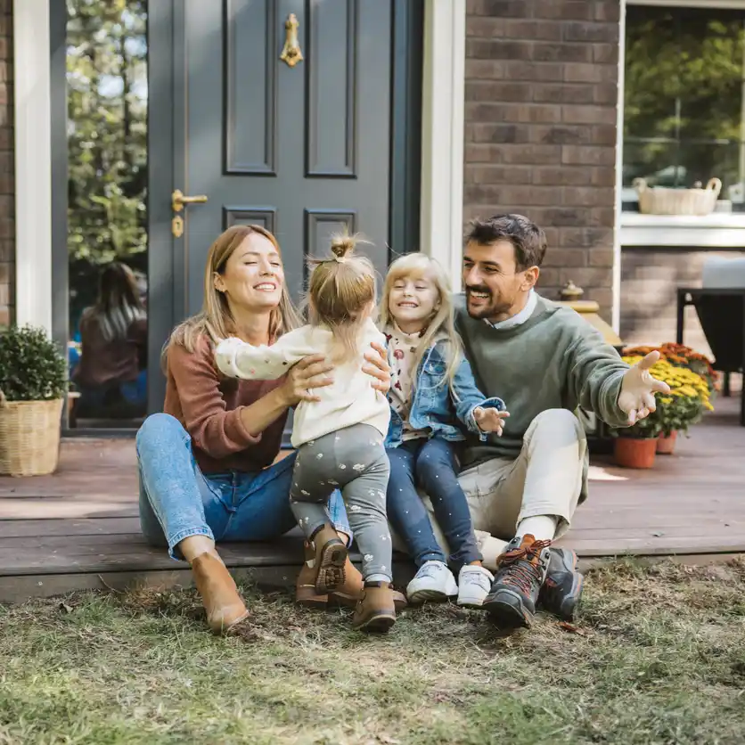 content strategy ideas australia.jpg Happy family of four at doorstep of home, having family hug.