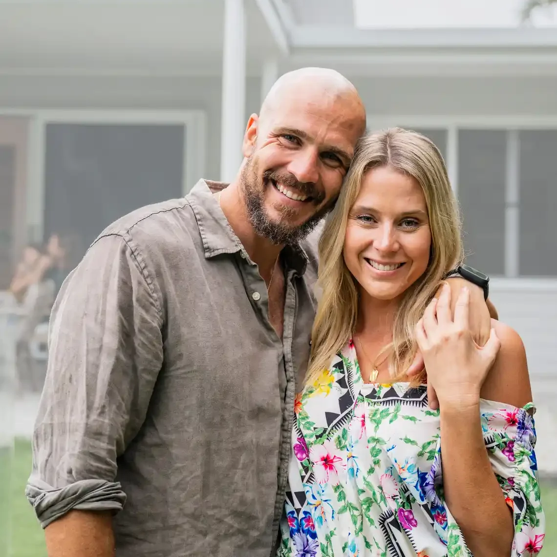 couple copywriting for small businesses in australia portrait Grounded looking couple with arms around one another portraying the perfect family real estate customers in front of their affluent style home.