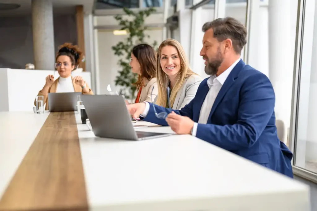 Mortgage broker shown seo tips on laptop in office with four professionals