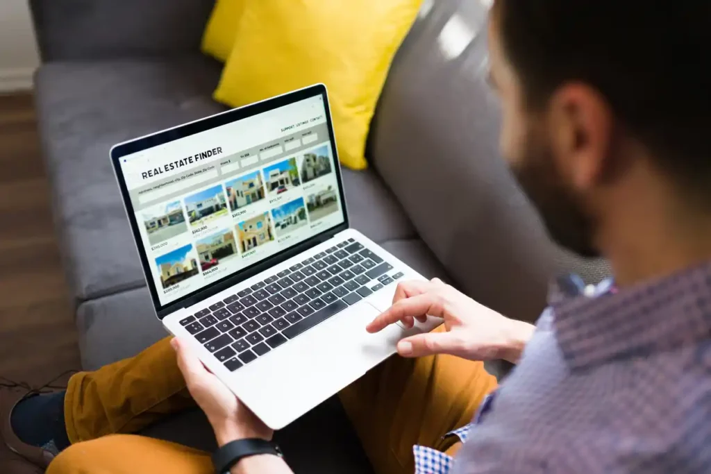 Copywriter looking at real estate website design on laptop on lap.