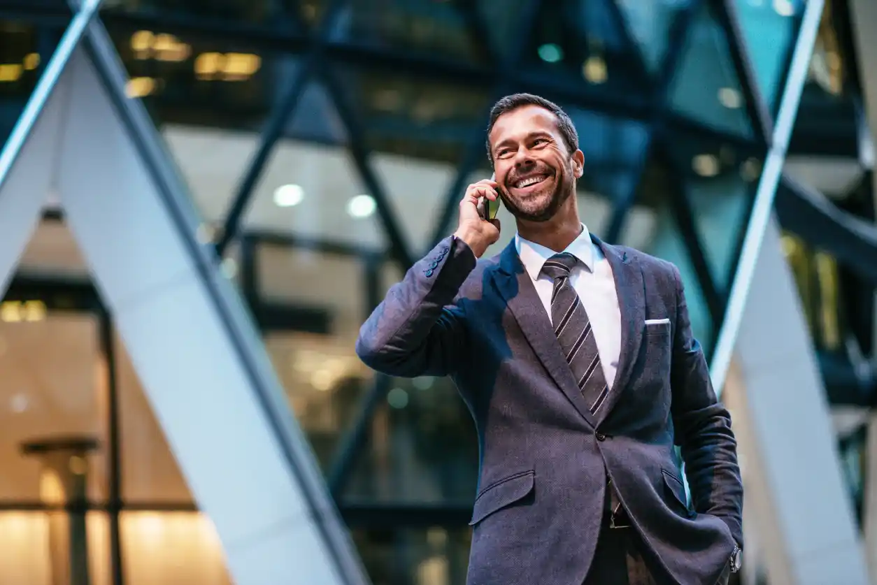 Expert finance broker standing with phone to ear in high power suit. 
